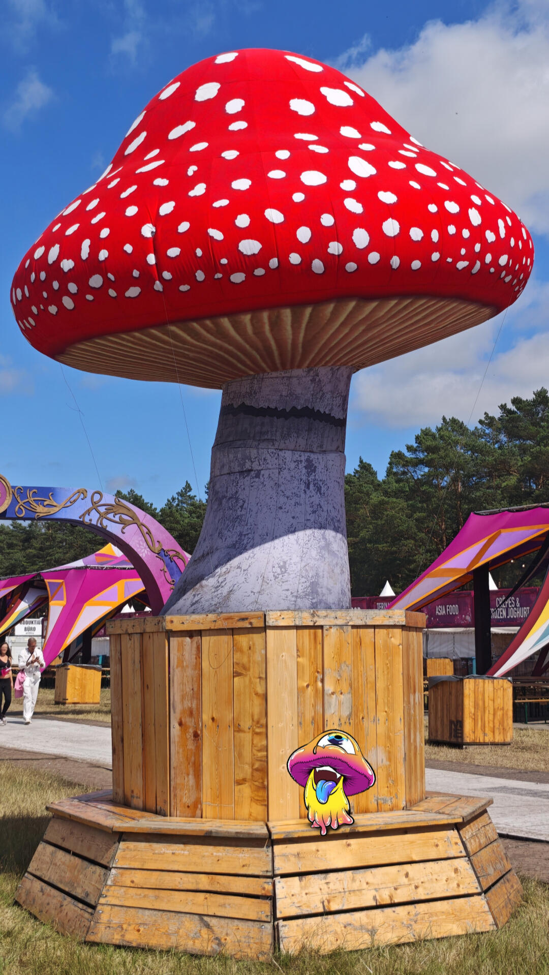 Mushy standing in front of a giant red mushroom decoration at Airbeat One.